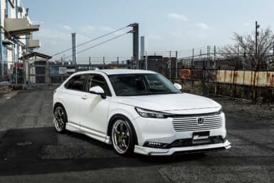 ホンダ ヴェゼル クール スタイルキット：スタイリッシュなSUVへ変貌を遂げたヴェゼル。純正の黒い樹脂部分を隠し、視覚的な重心を下げることでワイド＆ローなシルエットを構築している
