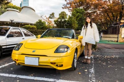 フィアット バルケッタ:オーナーのひかりさんと愛車の2000年式フィアット バルケッタ。鮮やかなイエローのボディが会場内でひと際目を引いた