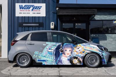 ホンダ フィット：車高調によるローダウンで、前後ともにバランスよく車高が下げられている。サイド一面に施工された鮮やかなラッピングデザインを、スポーティなシルエットがさらに引き立てる