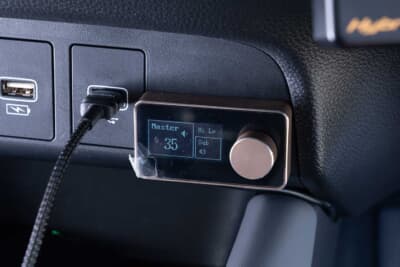 ホンダ フィット：運転席のすぐ横には、PLUG&PLAY 1080のDSPプロセッサーアンプを操作するためのコマンダーが設置されている。推しの楽曲に合わせて、手元で細かな音響調整が可能だ