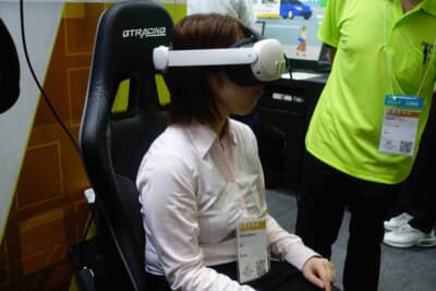 ジェイテクト：VRヘッドセットを装着し、格納ステアリングコラムが実現する未来のコクピットを体験する来場者
