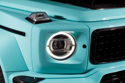 メルセデスAMG G63：丸型LEDヘッドライトのまわりまでボディ同色で塗り込み、ボンネット縁やバンパー下部にカーボンをのぞかせる