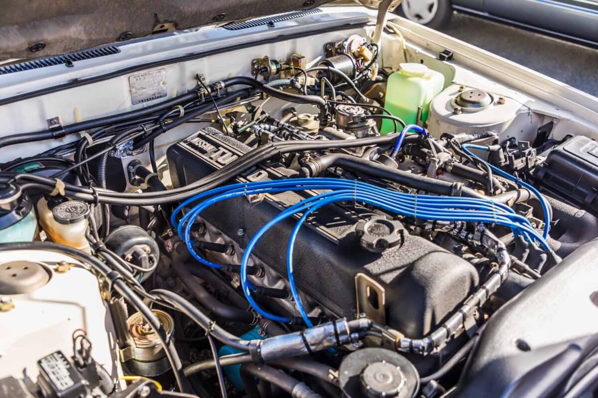 日産 レパード：整然と整備されたエンジンルーム。直列6気筒L20ET型ターボに鮮やかなブルーのプラグコードが映え、各部のクリーンな状態から手厚い管理ぶりがうかがえる