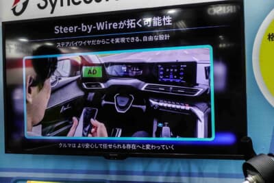 ジェイテクト：自動運転中にステアリングをダッシュボード奥へ格納し、スマートフォンを操作できる未来のシーンを示した展示映像