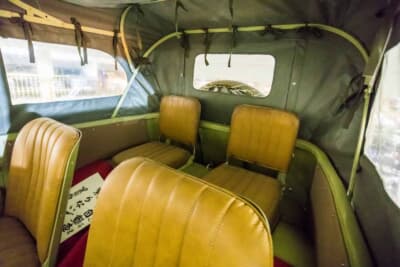 日本内燃機 九五式小型乗用車：折り畳めるリアシートを備えた後席。幌に開いた小窓と赤い床が、軍用車らしい簡素な室内空間を伝える