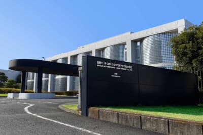 日産モータースポーツ&カスタマイズ 本社：旧オーテックジャパン時代から続く本社外観。初代社長就任の際、直列6気筒エンジンのイメージを建物のデザインに反映させたと故・櫻井眞一郎氏は語った
