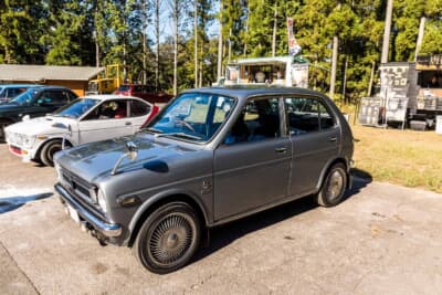 ホンダ ライフ CUSTOM:旧車が並ぶ会場に展示されたシルバーメタリックの4ドアボディを前方から見たサイドビュー