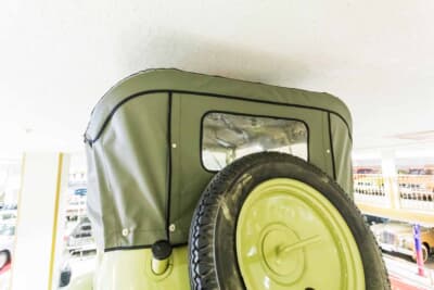 日本内燃機 九五式小型乗用車：背面に背負う大径スペアタイヤと幌の後ろ姿。グレーの幌に開いた小窓と丸みのある面構成が戦前車らしい意匠を伝える