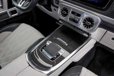 メルセデス・ベンツ G63：カーボン調パネルとダイヤルが並ぶセンターコンソールにDシェイプステアリングが調和する