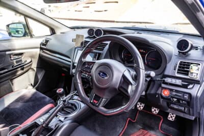 スバル WRX STI:ステアリングやシフトまわりは純正を活かした室内。レッドステッチが走りへの気持ちを高める