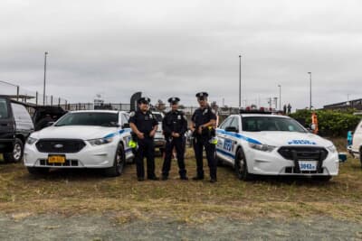 フォード ポリス・インターセプター・セダン：警察官のコスプレをしたオーナーたちと並ぶ2台。2019年に生産終了したこの車両の希少性を物語る記念の一枚である