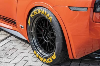 日産 フェアレディZ:ADVANのロゴ入りタイヤとブラックの多スポークホイールがオレンジボディに映える
